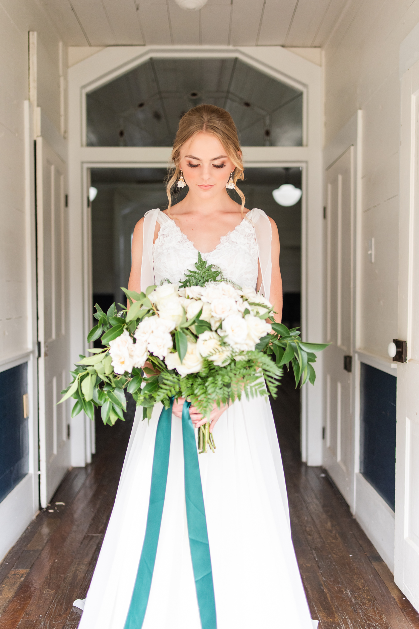 Bridal Portrait with a white and green bridal bouquet at the chapel door of the Inn at Salado.